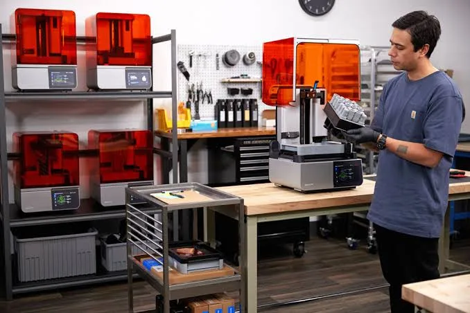 วิศวกรกำลังตรวจสอบชิ้นงานที่พิมพ์เสร็จจากเครื่องพิมพ์ Formlabs SLA ในแล็บการผลิต